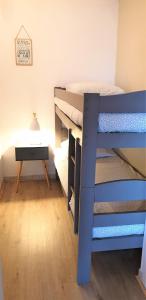 ein Schlafzimmer mit einem Etagenbett und einem Schreibtisch in der Unterkunft Appart Bréti Plage 1 - avec parking in Brétignolles-sur-Mer