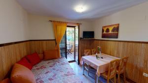 ein Zimmer mit einem Tisch und einem Sofa sowie einem Tisch und Stühlen in der Unterkunft Casa Del Sol Bed&Breakfast in Sukošan