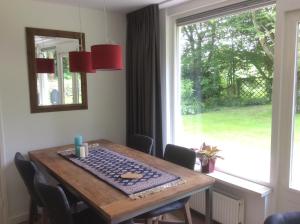 einen Esstisch mit Blick auf ein Fenster in der Unterkunft Vakantiehuisje vlakbij de duinen in Oostvoorne