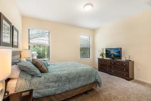 a bedroom with a bed and a television in it at Family Friendly - South Facing Pool - Game Room - Gated - Near Disney in Davenport +21 photos