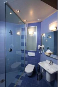 Baño azul con aseo y lavamanos en Hotel Eva, en Perm