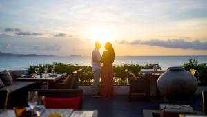 a couple standing in front of the sunset at a restaurant at InterContinental Pattaya Resort by IHG in Pattaya South
