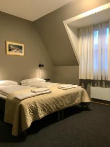 a bedroom with a bed with two towels on it at Henriks Hotell in Skien