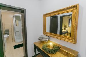 un miroir sur un mur à côté d'une table avec une bougie dans l'établissement Anda Apartment, à Azuga