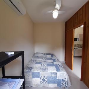 a bedroom with a bed with a blue and white quilt at Moradas Cantinho da Guarda in Guarda do Embaú