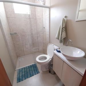 a bathroom with a shower and a toilet and a sink at Moradas Cantinho da Guarda in Guarda do Embaú