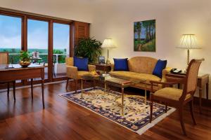 a living room filled with furniture and a large window at The Oberoi Bengaluru in Bangalore
