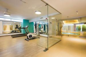 a gym with exercise equipment and a glass wall at Hotel Riu San Francisco - Adults Only in Playa de Palma