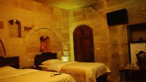 Un pat sau paturi într-o cameră la Family Cave Suite Hotel