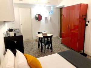 una habitación con una mesa pequeña y una puerta roja en Residenza Pedrotti, en Vicenza