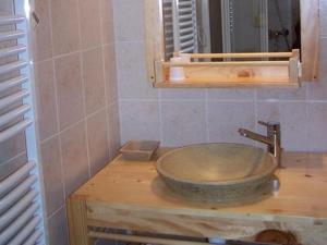 a bathroom with a stone sink on a wooden counter at Les Grands Champs in Attignat-Oncin