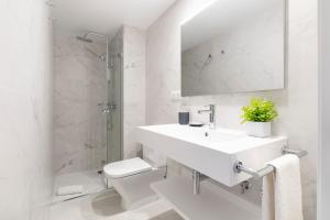 a white bathroom with a sink and a toilet at Aspasios Las Ramblas Apartments in Barcelona +10 photos