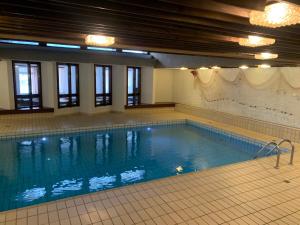 a large swimming pool with blue water in a building at Quellenhof C01 in Davos