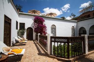 ein weißes Haus mit einem Zaun und Blumen in der Unterkunft Riad Clémentine in Marrakesch
