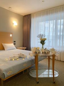 una habitación de hotel con una cama y una mesa con platos. en Hotel Eva, en Perm