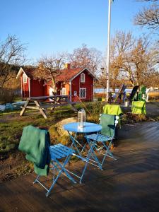 una mesa azul y dos sillas y una casa roja en Notholmen, Tyresö, en Tyresö