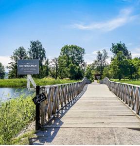 a bridge over a river with a sign on it at Notholmen, Tyresö in Tyresö