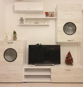 a living room with a television on a white entertainment center at Cosy Charming Apartment in Blagoevgrad