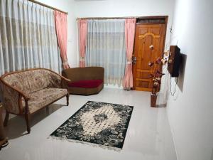 un soggiorno con divano, sedia e porta di Bukittinggi Homestay 2 a Bukittinggi