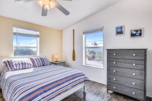 a bedroom with a bed and a dresser and two windows at Cayo Loco in Little Torch Key