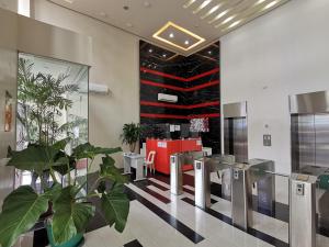 马尼拉G Square Residences的设有等候区的大厅，等候区内有一株植物