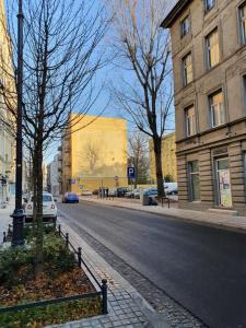 une rue de la ville avec un bâtiment jaune en arrière-plan dans l'établissement Rzut beretem od Piotrkowskiej / A stone's throw from Piotrkowska, à Łódź