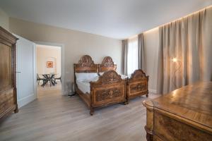 een slaapkamer met een groot houten bed en een tafel bij Casa Guarnieri in Feltre