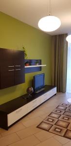 a living room with a flat screen tv on a cabinet at Palanga Apartaments - Mickevičiaus 8 in Palanga