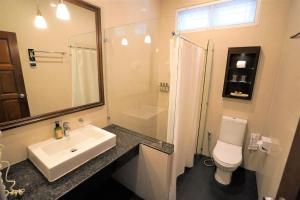 a bathroom with a sink and a toilet and a mirror at Samed Villa Resort in Ko Samed