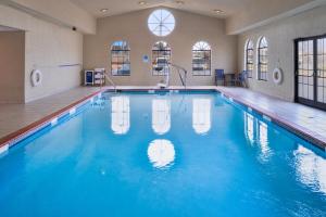 a swimming pool with blue water in a building at Spark By Hilton North Little Rock in North Little Rock