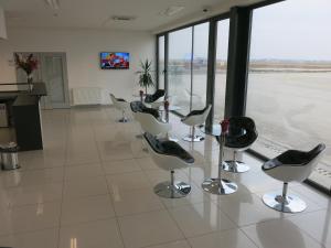 a row of chairs and a table in an airport terminal at Elmontex Air in Mošnov