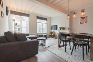 una sala de estar con un sofá y una mesa en Appartement De Croone, en Middelburg