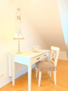 a white desk with a chair and a lamp at Romantic Style Apartment Titisee-Neustadt in Titisee-Neustadt