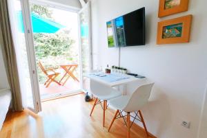 a room with a table and chairs and a balcony at Beachfront Apartment Mala Tereza in Split