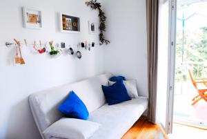 a living room with a white couch with blue pillows at Beachfront Apartment Mala Tereza in Split