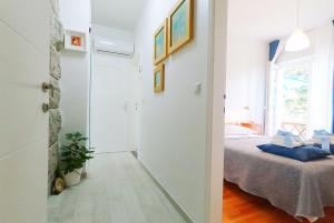 a white room with a bed and a window at Beachfront Apartment Mala Tereza in Split