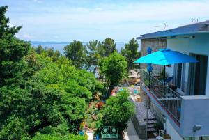 a balcony with a blue umbrella on a building at Beachfront Apartment Mala Tereza in Split