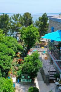 a view of a garden with a blue umbrella at Beachfront Apartment Mala Tereza in Split