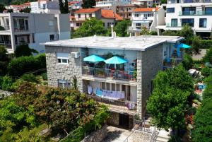 an apartment building with a balcony with umbrellas at Beachfront Apartment Mala Tereza in Split