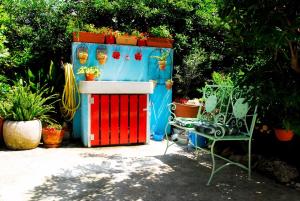 a blue and red shed with a bench and plants at Beachfront Apartment Mala Tereza in Split