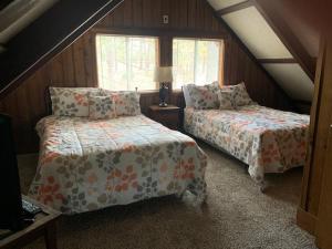 a attic bedroom with two beds and a window at Pine Mountain Club Chalets Resort in Pine Mountain