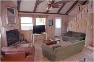 een woonkamer met banken, een tv en een open haard bij Pine Mountain Club Chalets Resort in Pine Mountain