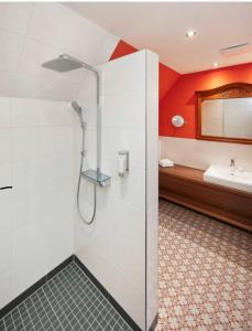 uma casa de banho com um chuveiro e um lavatório. em Hotel Anno 1848 em Lindern