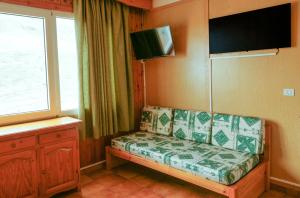 a living room with a couch and a tv on the wall at Kione Sapporo in Pas de la Casa