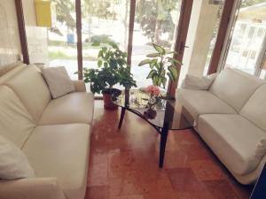 a living room with two white couches and a table at Apart Hotel Central Razgrad in Razgrad