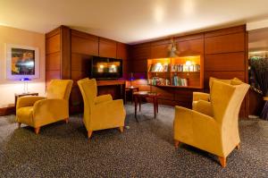 a room with chairs and a table and a television at Hotel Marques De Pombal in Lisbon