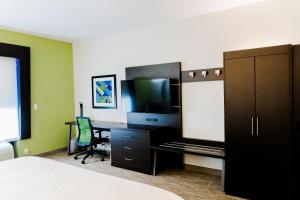 1 dormitorio con escritorio, TV y ordenador en Holiday Inn Express Hotel & Suites Greenville, an IHG Hotel, en Greenville