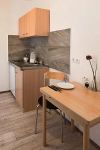 a small kitchen with a wooden table and a table and chairs at City Apart Hotel in Düsseldorf