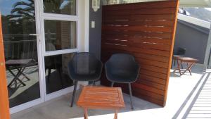 2 sillas y una mesa en el patio en Bloemenzee Boutique B&B en Gordonʼs Bay