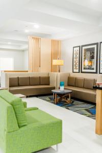 uma sala de estar com sofás e uma mesa em Holiday Inn Express Hotel & Suites Greenville, an IHG Hotel em Greenville